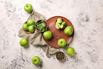 Plate with fresh ripe apples on light background