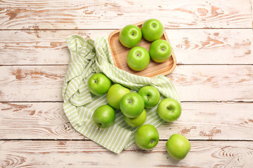 Fresh ripe apples on light wooden background
