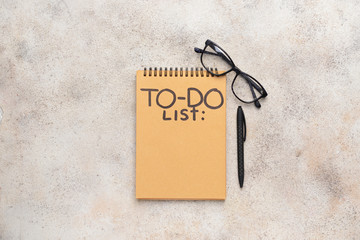 Empty to do list, glasses and pen on light background
