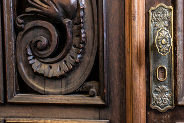 old metal doorknob on an ornate wooden door inside a church in Brazil