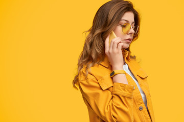 Attentive woman in bright clothes talking on phone