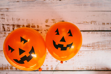 Orange pumpkin balloons for Halloween party on white wooden background. Happy Halloween. Holiday concept with colorful balloon.