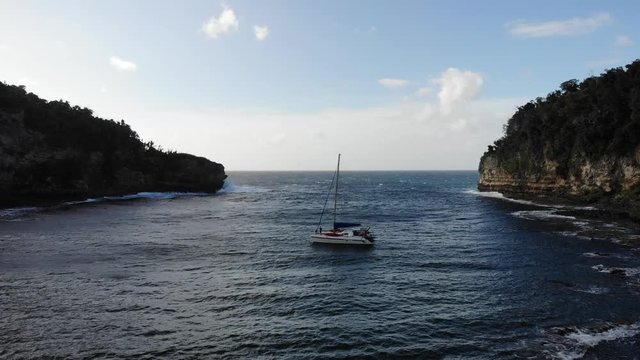 Catamaran yacht anchored in a sheltered bay to avoid the storm
