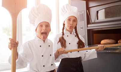 Funny kids baking bread and showing tongue