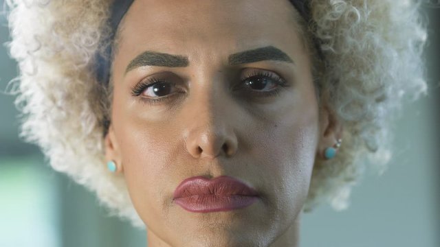 Transgender woman looking at camera with sad expression