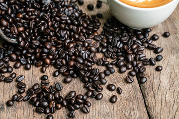 Latte art coffee in cup on wooden table with coffee bean