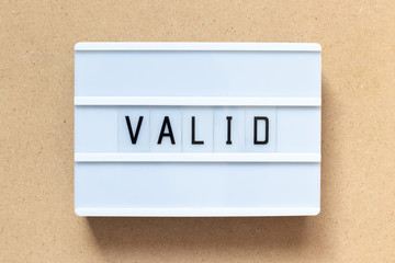 White lightbox with word valid on wood background