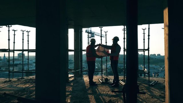 Engineers in uniform work with a bluprint.