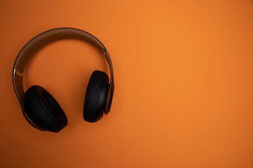 bluetooth kopfhoerer auf orangenen hintergrund - wireless headset on orange background