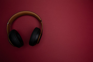 bluetooth kopfhoerer auf weinrotem hintergrund - wirless headset on winered background