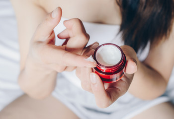 Cropped shot view of young woman using moisturizer cream or lotions to enhance the appearance of the face and body. Conceptual of beauty and health care skin.