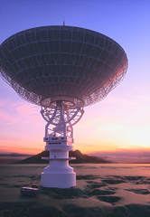 Huge satellite antenna dish for communication and signal reception out of the planet Earth. Observatory searching for radio signal in space at sunset.
