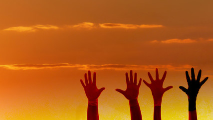  silhouette hands on the beautiful sunset sky . help and team ,teamwork concept.