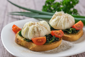 Poached eggs with bread and green onions on a white plate.