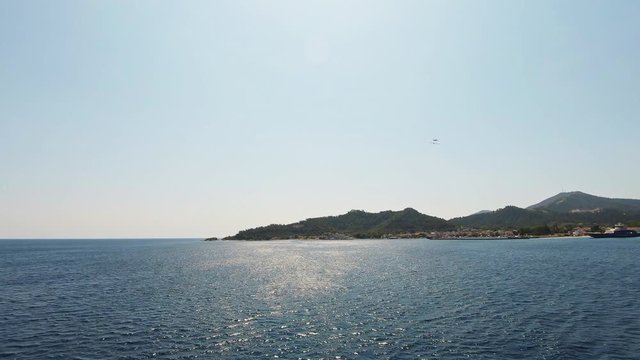 THASOS, GREECE - JULY 5 2019: Ferry boat leaving Limenas, the Port of Thasos on a sunny summer day.