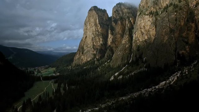 Flight along the cliffs of Langental in southern Tyrol. Alpine spires, and sheer rock faces and low hanging clouds.