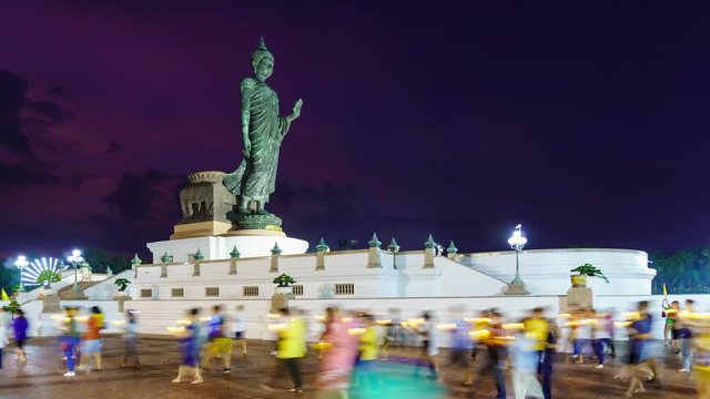 Candle procession ceremony around buddha statue in twilight on Vesak day or Buddha Birthday at Phuttha Monthon Buddhist park, Nakhon Pathom, Thailand - Time-Lapse