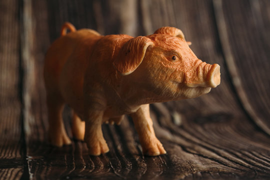 figurine of a toy pig on a wooden background