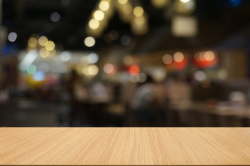 Empty dark wooden table in front of abstract blurred bokeh background of restaurant . can be used for display or montage your products.Mock up for space.