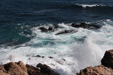 waves crushing against the rocks in the sea