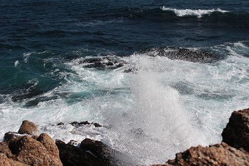 waves crushing against the rocks in the sea