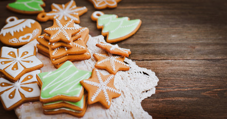 festive Christmas gingerbread cookies in the shape of a star lie on a wooden dark brown background.