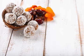 Homemade dietary candies from dates and an apricot in coconut topping. Selective focus. Copy space