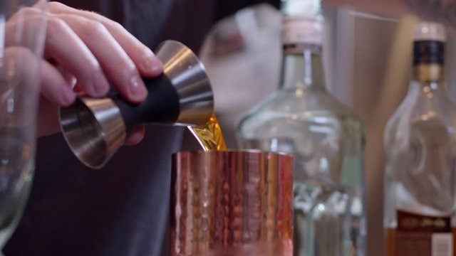 Bartender poouring shots into shaker