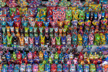 Fototapeta na wymiar Sale of souvenirs - funny handmade wooden animals in street market. Bright colorful children toys and decoration for interior. Ubud, Bali island, Indonesia. Closeup