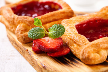 Berry pies and coffee in a cup on a white wooden background. Selective focus.