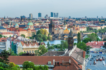 Obraz premium Aerial view of citycape of old town of Prague, with a lot of rooftops, churches, and the landmark of Charles Bridge, and Vltava river. view from the Letna park.