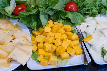 Assortment of cheese, close up. Background of many pieces of fresh cheese all cut into cubes during the buffet