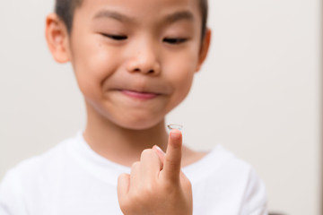 Asian kids hold with a contact lens