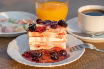 Curd cheese with red cherry jam, orange juice and cup coffee on table. Breakfast concept