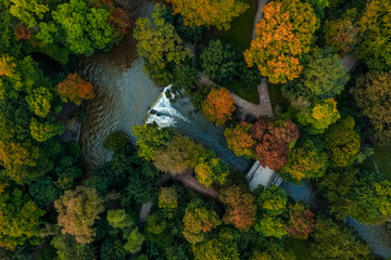 Beautiful autumn scenery by a flight with a drone over colored trees in a park.