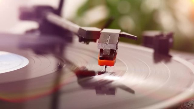 Close-up shot of a vinyl record spinning on a turntable. Relaxing and listening to music at home in casual atmosphere