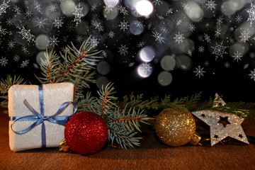 Fototapeta na wymiar beautiful Christmas photo with twigs of spruce, Christmas toys on the background of falling snow