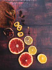 Christmas ingredients background with cinnamon sticks, dried apples, cranberries, cardamon, raisin, fruitson wooden surface, copy space, top view