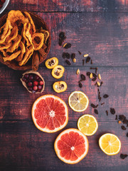 Christmas ingredients background with cinnamon sticks, dried apples, cranberries, cardamon, raisin, fruitson wooden surface, copy space, top view