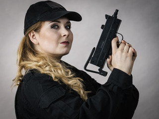 Woman holds gun in hands.