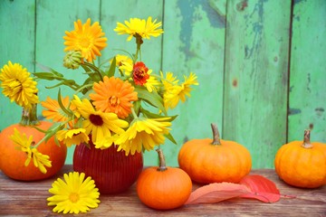 Naklejka na ściany i meble Herbstdekoration mit Kürbissen und Blumenstrauß in orange