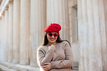 Plus zise model wearing sweater and beret posing on the city street