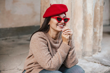 Plus zise model wearing sweater and beret posing on the city street