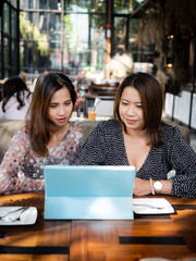 Asian women using tablet in cafe together, lifestyle concept.