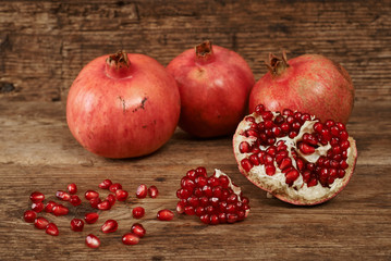 ripe pomegranate fruits on wooden table.