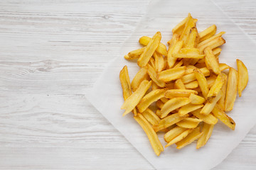 Homemade french fries on a white wooden surface, top view. Flat  lay, overhead, from above. Space for text.