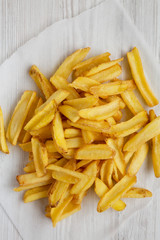 Homemade french fries with salt on a white wooden background, top view. Flat lay, overhead, from above. Close-up.