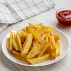 Homemade french fries with sour-sweet sauce on a white plate, ішву view. Close-up.