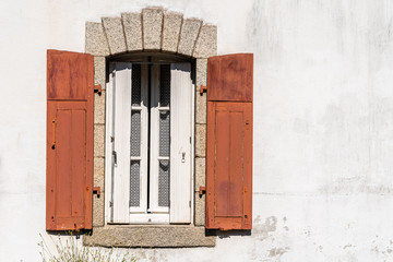 Old window with wooden red painted shutters