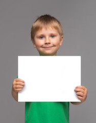 Portrait of happy smiling boy in green t-shirt. Attractive kid in studio. Childhood concept.